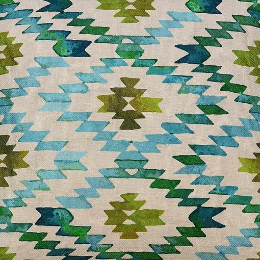 Close up image of teal and green square cushion with zigzag patterns