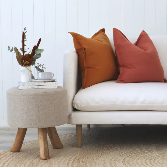 Two pure linen cushions sit on a white sofa near side table