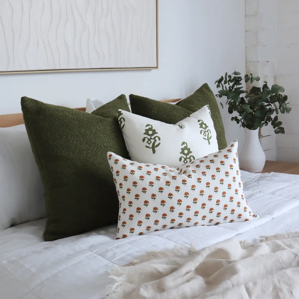 Cushions styled on a bed. The arrangement includes cushion covers in different sizes.