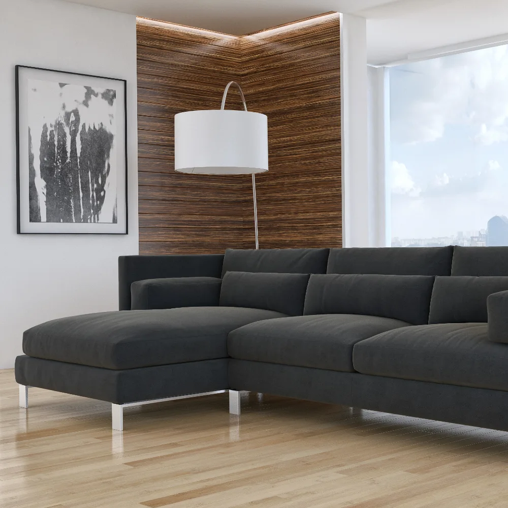 A black sofa sits on a wooden floor against a modern styled wall with artwork.