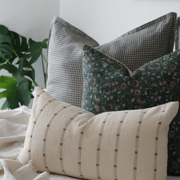 Three luxury cushions styled on a bed.