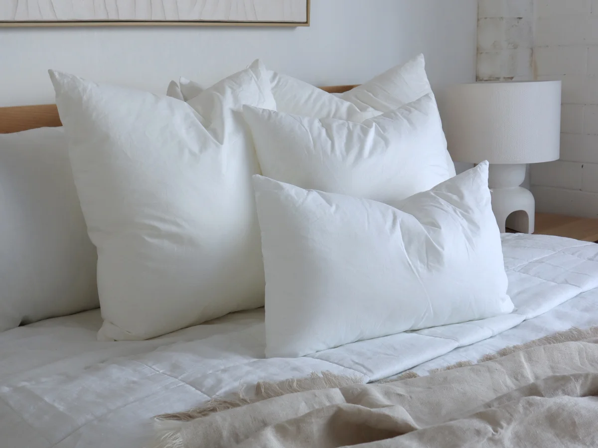 A collection of four quality cushion inserts arranged on a bed.