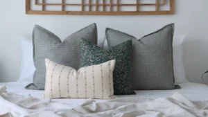 Four different cushion sizes arranged on a bed.