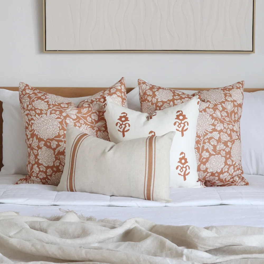 Some classic cushions in an arrangement on a bed.