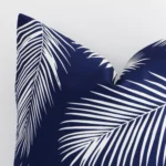 Magnified view of this outdoor navy cushion cover’s corner showing a palm design and its square size.