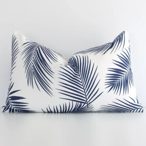 Navy outdoor cushion cover features prominently against a white wall. It is a rectangle design and has a palm decorative finish.