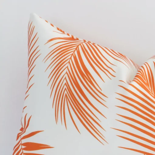 A rectangle orange outdoor cushion cover’s corner is shown in more detail. It is possible to see the palm decorative finish in much more detail.