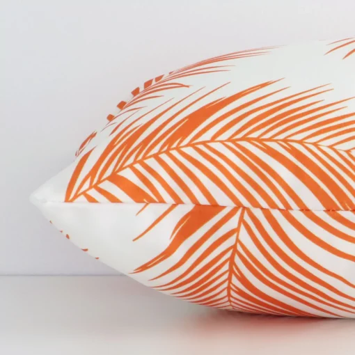 A rectangle orange palm styled cushion positioned on its back panel. The shot shows a lateral view of the outdoor fabric.