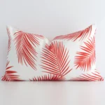 A graceful rectangular red cushion with a palm style on durable outdoor fabric.