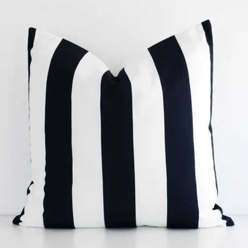 A lovely large black and white cushion cover arranged in front of a white wall. The striped style complements the outdoor material.