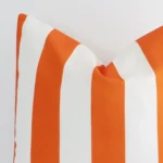 A zoomed view of this large outdoor orange cushion’s corner that shows a magnified view of its striped design and its corner.