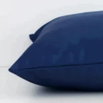 Lateral viewpoint of this outdoor square cushion. The solid-coloured design and blue colour is shown from the side showing the front and rear panels.