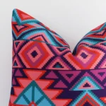 Close up view showing a corner of this geometric outdoor cushion in a square shape.