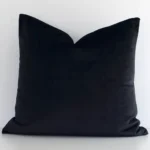 An alluring velvet square cushion cover in black. It features an attractive solid-coloured style.