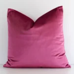 A bold solid-coloured velvet cushion in a sleek square size with a blush tone of colour.