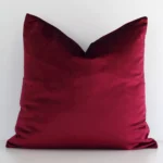 A stunning square velvet cushion in a burgundy colour. It has an exquisite solid-coloured design.