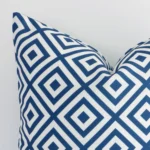 Close up image of top corner of this geometric blue cushion. This shows the outdoor fabric and square shape up close.