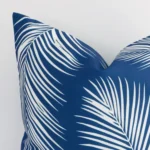 Zoomed photo of the top left corner of this blue palm designed cushion cover. The image clearly shows the ourdoor material and square dimensions.