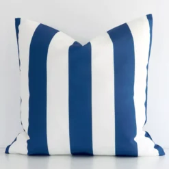 A hero shot of a striped large cushion cover. It is made from a deluxe outdoor fabric and features a navy colour.