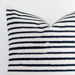 Corner section image showing features of large cushion that has a stripe motif on its linen fabric.