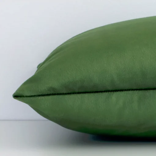 Side image of a velvet square cushion cover. The solid-coloured design and forest green colour are visible from the side showing the attachment of the panels.