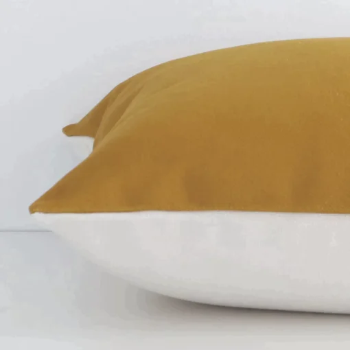 A mustard solid-coloured cushion positioned on its back panel. The shot shows a lateral view of the linen fabric and its square size.