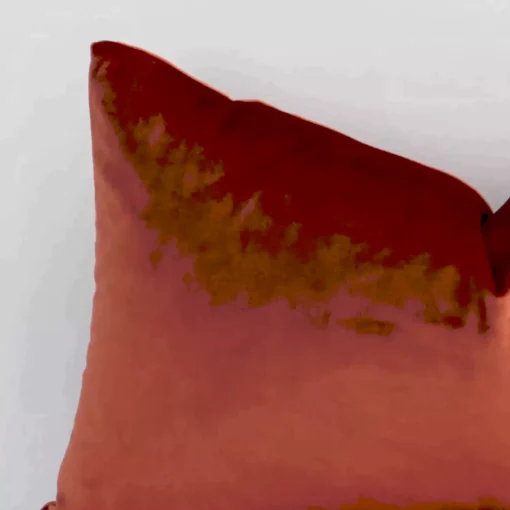 Close range image of rust cushion. The rectangle size and velvet material can be seen in detail.