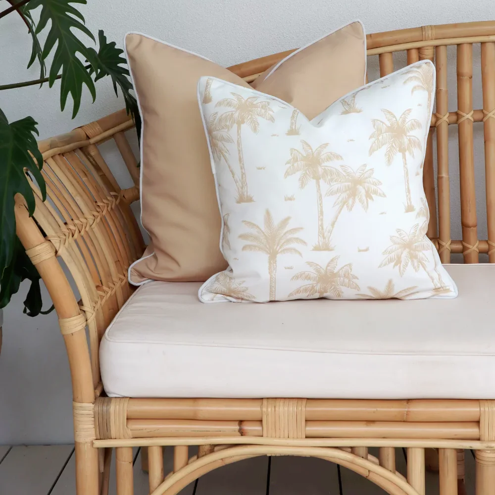 Two beige outdoor cushions that contrast against each other placed on an outdoor seat.